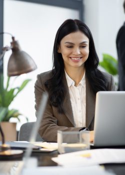 cerrar-mujer-sonriente-trabajando-computadora-portatil